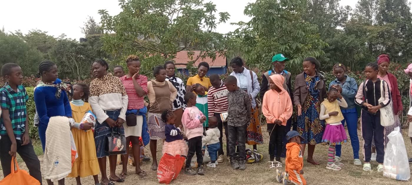 Mothers and children standing together with the food they have received