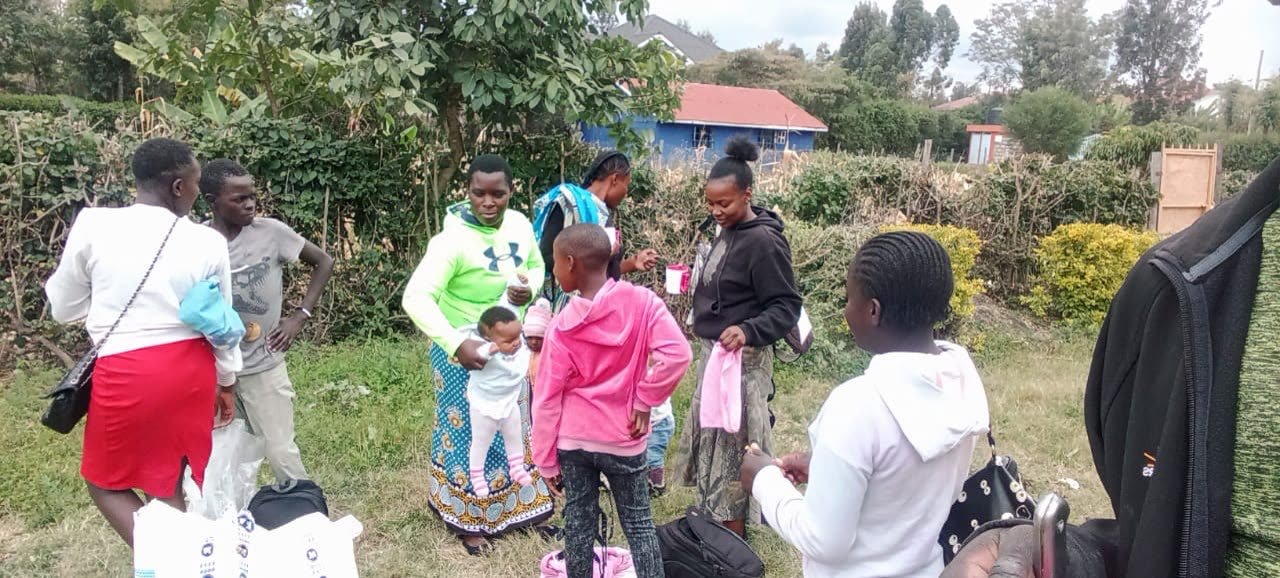 Volunteers handing parcels to mothers and children at a distribution