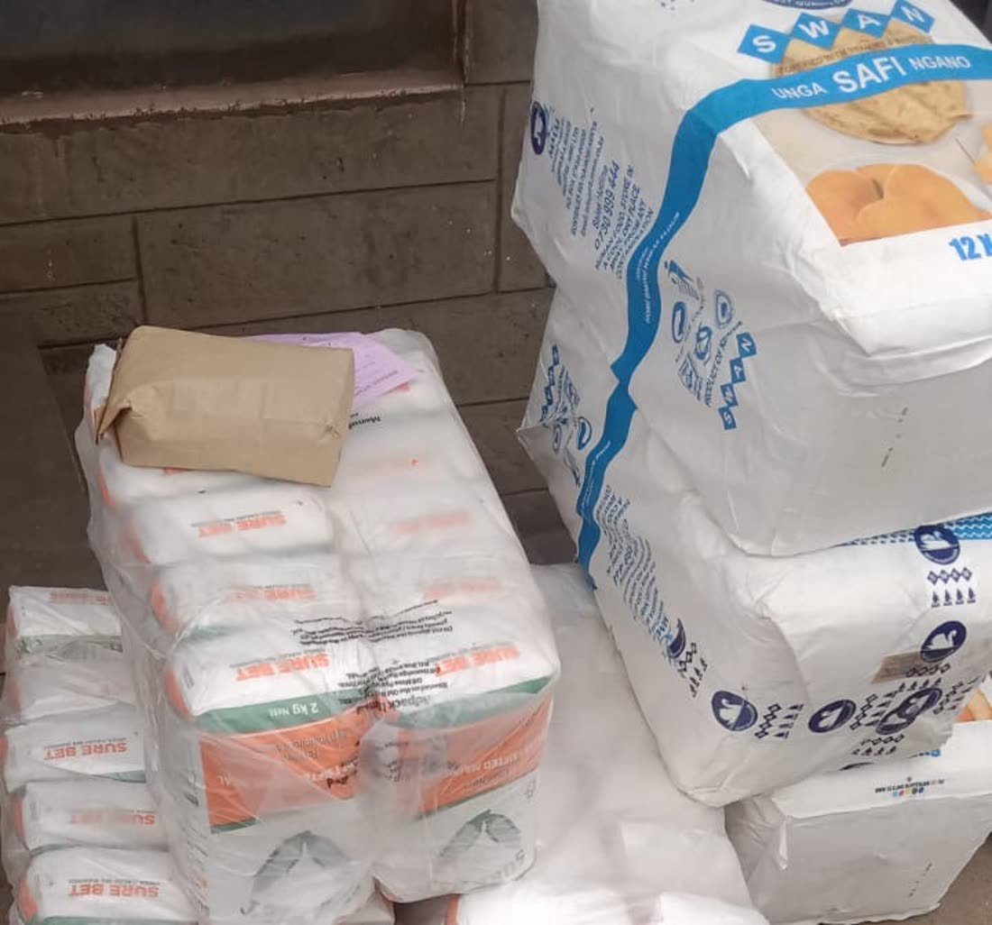 Stacked packets of maize flour and sacks of wheat flour ready for distribution